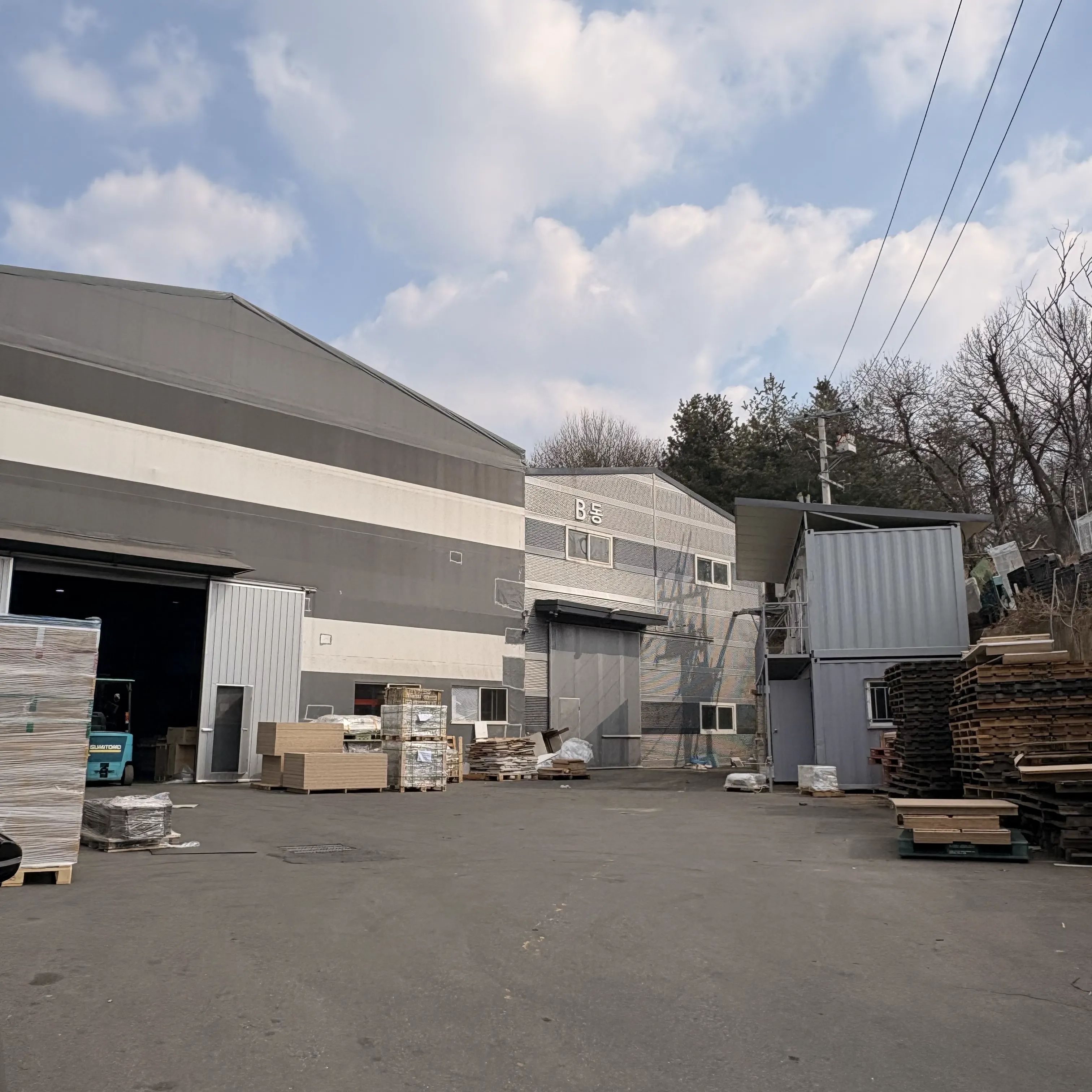 B동 건물 외관 - 야적장과 지게차